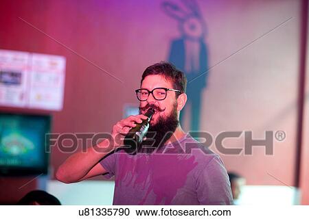 Portrait of man drinking bottle of beer in bar View Large Photo Image Stock Image - Portrait of man drinking bottle of beer in bar. Fotosearch