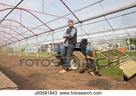 Portrait of organic farmer with tractor in polytunnel View Large Photo Image Stock Image - Portrait of organic farmer with tractor in polytunnel. Fotosearch