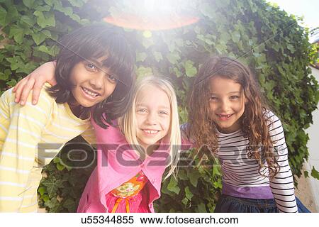Stock Photography - Portrait of three girls in garden. Fotosearch