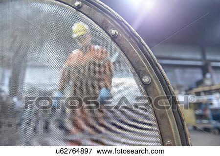 Portrait of worker behind industrial sieve in steel foundry View Large Photo Image Stock Photo - Portrait of worker behind industrial sieve in steel foundry. Fotosearch