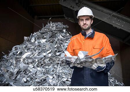 Stock Photo - Portrait of worker holding scrap aluminum. Fotosearch