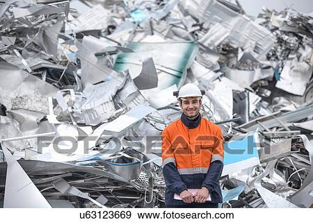 Stock Photo - Portrait of worker in front of scrap aluminum. Fotosearch