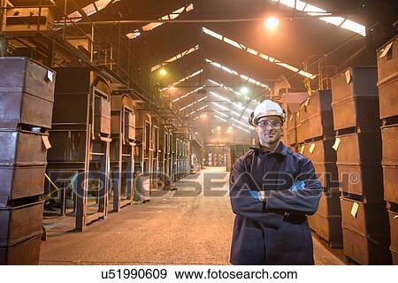 Portrait of worker next to crates of steel shot in steel foundry View Large Photo Image Stock Photo - Portrait of worker next to crates of steel shot in steel foundry. Fotosearch