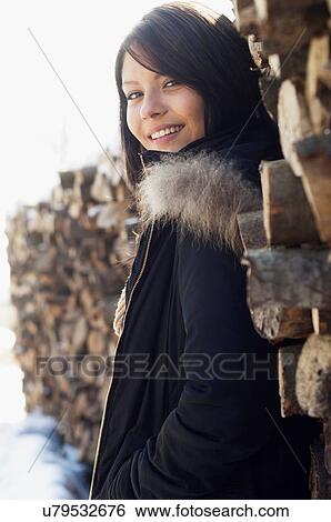Portrait of young female in front of log pile View Large Photo Image Stock Photograph - Portrait of young female in front of log pile. Fotosearch