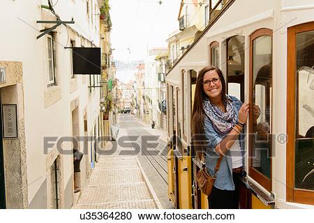 Portrait of young female tourist riding tram in Lisbon, Portugal View Large Photo Image Stock Image - Portrait of young female tourist riding tram in Lisbon, Portugal. Fotosearch