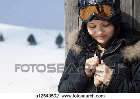 Stock Image - Portrait of young female wearing ski goggles. Fotosearch