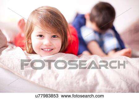 Portrait of young girl smiling and brother sulking View Large Photo Image Stock Image - Portrait of young girl smiling and brother sulking. Fotosearch