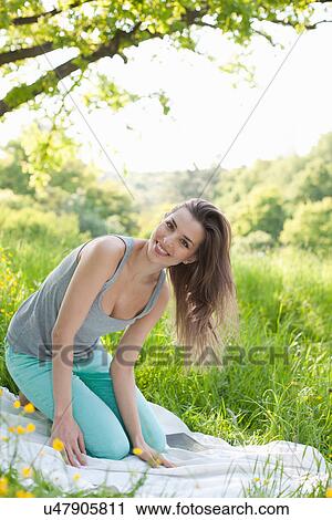 Portrait of young woman kneeling on picnic blanket View Large Photo Image Stock Image - Portrait of young woman kneeling on picnic blanket. Fotosearch