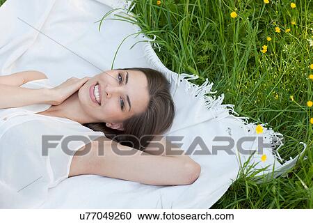 Portrait of young woman lying in field of buttercups View Large Photo Image Stock Image - Portrait of young woman lying in field of buttercups. Fotosearch