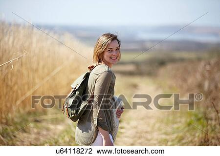 Portrait of young woman on dirt track next to field of reeds View Large Photo Image Stock Image - Portrait of young woman on dirt track next to field of reeds. Fotosearch