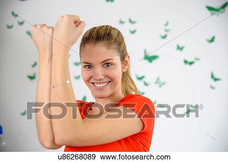 Portrait of young woman practicing arm exercise at home View Large Photo Image Stock Photo - Portrait of young woman practicing arm exercise at home. Fotosearch