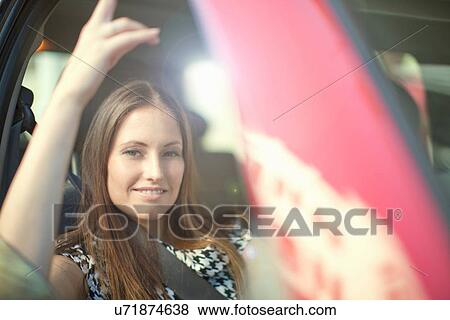 Portrait of young woman sitting in car View Large Photo Image Stock Photo - Portrait of young woman sitting in car. Fotosearch