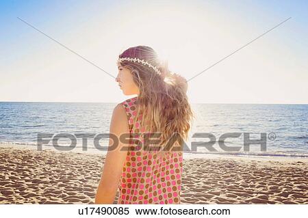 Stock Photography - Profile of girl on beach with hand in hair. Fotosearch