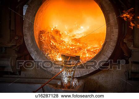Stock Photo - Raking liquid aluminum from furnace at recycling plant. Fotosearch