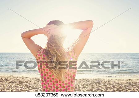 Rear view of girl on beach with hands in hair View Large Photo Image Stock Photo - Rear view of girl on beach with hands in hair. Fotosearch