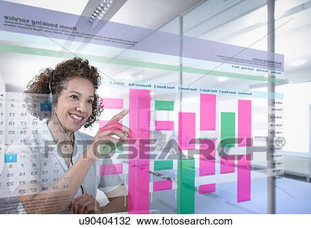 Stock Image - Receptionist booking meeting rooms with interactive screen. Fotosearch