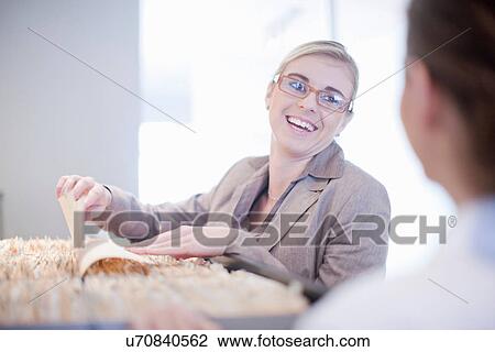 Stock Image - Receptionist looking through hospital index cards. Fotosearch