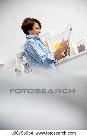 Senior woman holding family photographs View Large Photo Image Picture - Senior woman holding family photographs. Fotosearch