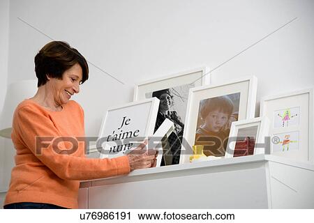Senior woman looking at family photographs View Large Photo Image Stock Image - Senior woman looking at family photographs. Fotosearch