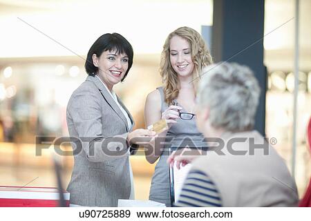 Shop assistant and customer in opticians shop View Large Photo Image Stock Photo - Shop assistant and customer in opticians shop. Fotosearch