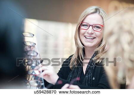 Shop assistant in opticians shop View Large Photo Image Stock Image - Shop assistant in opticians shop. Fotosearch