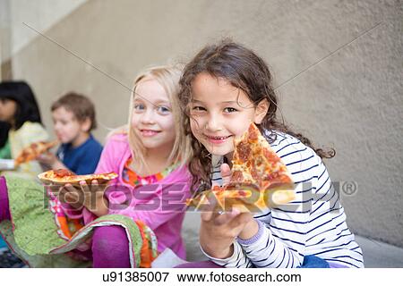 Small group of children eating pizza outdoors View Large Photo Image Stock Photo - Small group of children eating pizza outdoors. Fotosearch