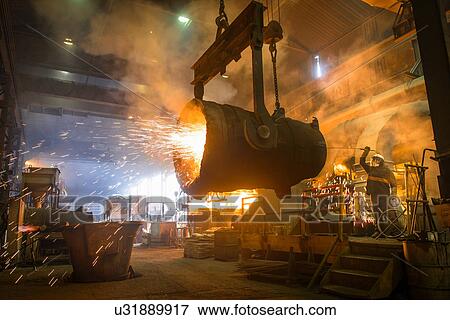 Stock Photo - Steel worker and bucket of molten metal in steel foundry. Fotosearch
