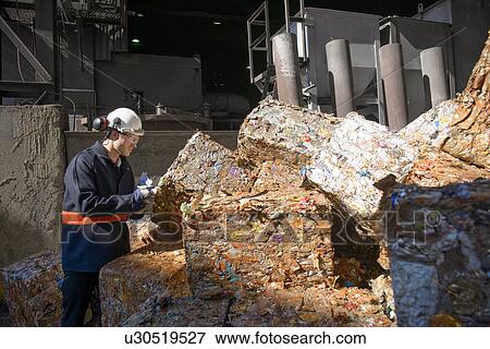 Steel worker examining scrap metal bales outside foundry View Large Photo Image Stock Photo - Steel worker examining scrap metal bales outside foundry. Fotosearch