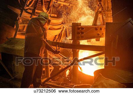 Steel worker looking down at furnace in steel foundry View Large Photo Image Stock Photograph - Steel worker looking down at furnace in steel foundry. Fotosearch