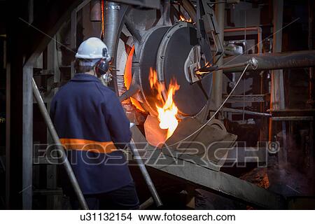 Picture - Steel worker pouring molten metal in steel foundry. Fotosearch