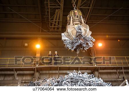 Steel workers watching mechanical grabber in steel foundry View Large Photo Image Picture - Steel workers watching mechanical grabber in steel foundry. Fotosearch