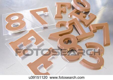 Stock Image - Still life of moulded chocolate numerals and letters. Fotosearch
