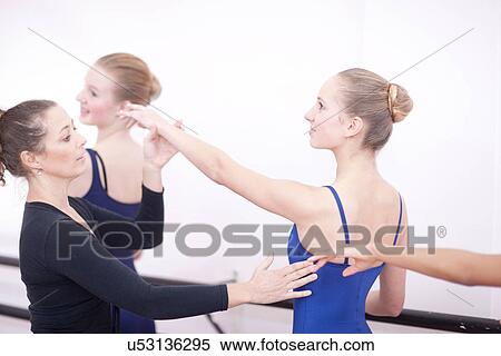 Stock Photography - Teacher adjusting teenage ballerinas arm pose. Fotosearch