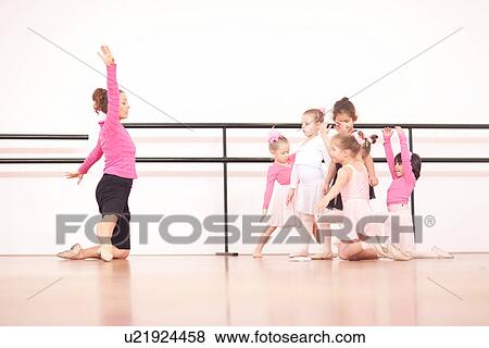 Teacher demonstrating to a group of young ballerinas View Large Photo Image Stock Photo - Teacher demonstrating to a group of young ballerinas. Fotosearch