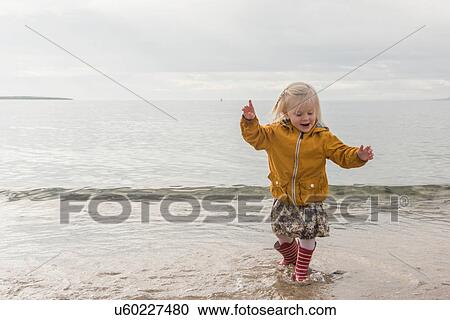 Toddler paddling at coast View Large Photo Image Stock Image - Toddler paddling at coast. Fotosearch