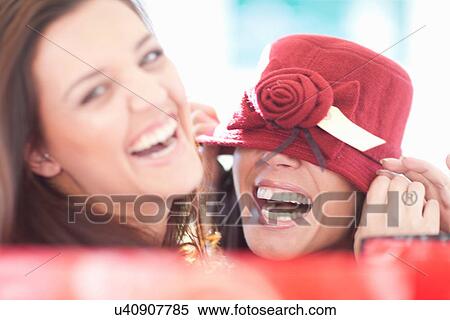 Two female friends fooling about with burgundy hat View Large Photo Image Stock Photography - Two female friends fooling about with burgundy hat. Fotosearch