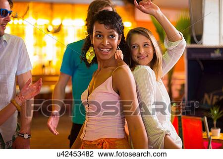 Two females dancing back to back in bar View Large Photo Image Stock Image - Two females dancing back to back in bar. Fotosearch