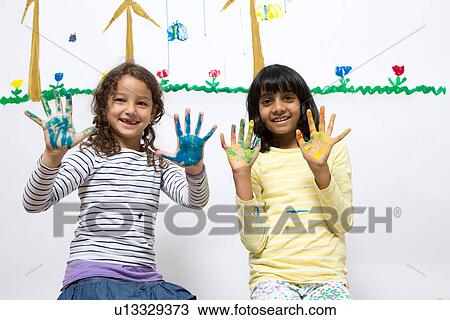 Two girls kneeling on floor with painted hands View Large Photo Image Stock Image - Two girls kneeling on floor with painted hands. Fotosearch
