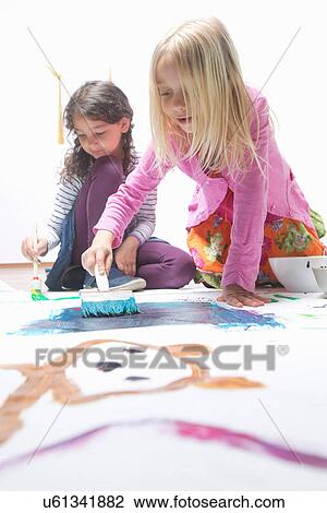 Two girls painting on floor View Large Photo Image Stock Image - Two girls painting on floor. Fotosearch