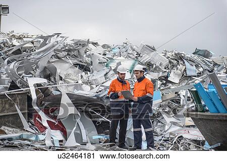 Two workers looking at clip board in front of scrap aluminum View Large Photo Image Stock Image - Two workers looking at clip board in front of scrap aluminum. Fotosearch