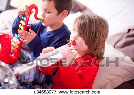 Stock Photo - Two young children playing toy instruments. Fotosearch