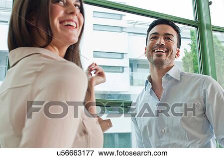 Two young colleagues having fun in office View Large Photo Image Stock Photo - Two young colleagues having fun in office. Fotosearch