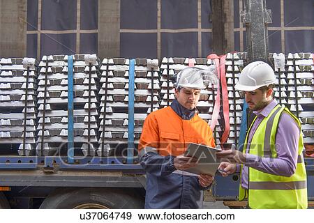 Warehouse workers checking truck cargo View Large Photo Image Stock Photo - Warehouse workers checking truck cargo. Fotosearch
