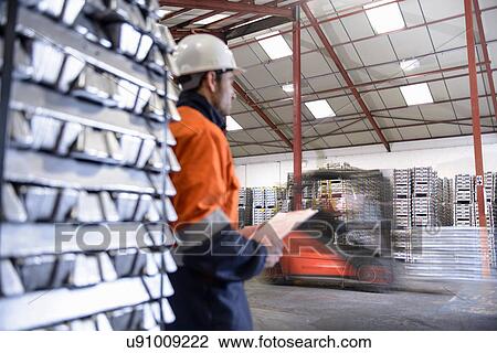 Warehouse workers moving stacked aluminum ingots View Large Photo Image Stock Image - Warehouse workers moving stacked aluminum ingots. Fotosearch