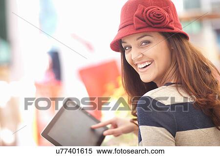 Woman in burgundy hat using digital tablet View Large Photo Image Stock Photography - Woman in burgundy hat using digital tablet. Fotosearch