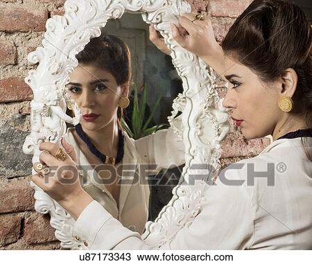 Woman in vintage clothes holding mirror View Large Photo Image Stock Image - Woman in vintage clothes holding mirror. Fotosearch