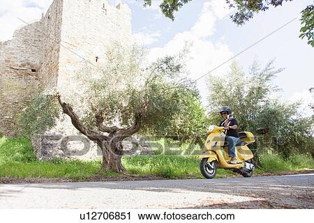 Woman on scooter riding around corner View Large Photo Image Stock Image - Woman on scooter riding around corner. Fotosearch