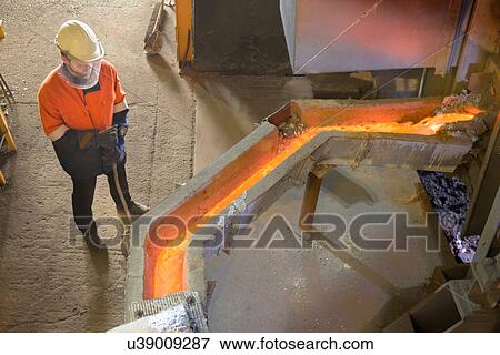 Worker monitoring molten metal at aluminum recycling plant View Large Photo Image Stock Photo - Worker monitoring molten metal at aluminum recycling plant. Fotosearch