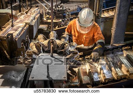 Worker testing metal ingots at aluminum recycling plant View Large Photo Image Stock Image - Worker testing metal ingots at aluminum recycling plant. Fotosearch