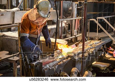 Worker testing molten metal at aluminum recycling plant View Large Photo Image Stock Photograph - Worker testing molten metal at aluminum recycling plant. Fotosearch